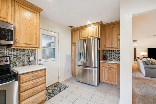a kitchen with stainless steel appliances granite countertop a refrigerator and a stove top oven