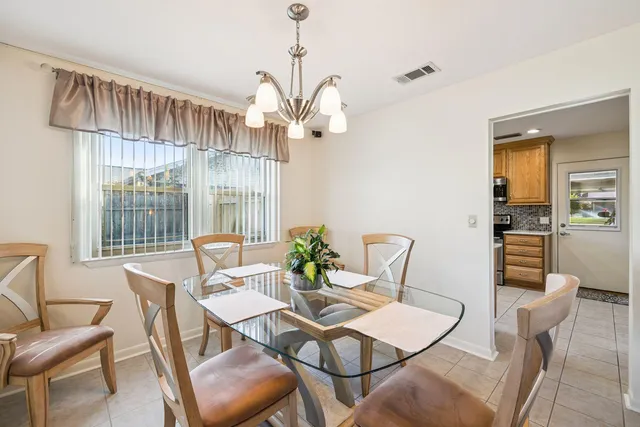 a dining room with furniture a chandelier and wooden floor