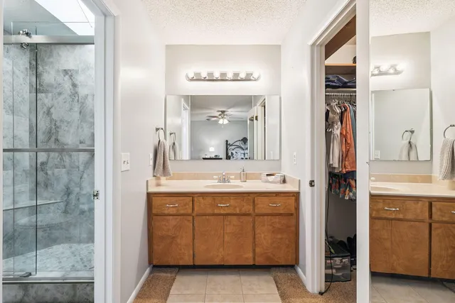 a bathroom with a double vanity sink a mirror and a shower