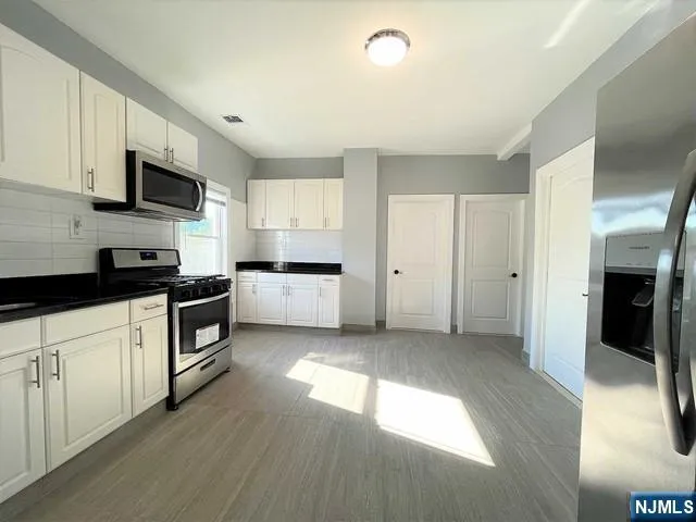 a kitchen with stainless steel appliances granite countertop a refrigerator and a stove top oven