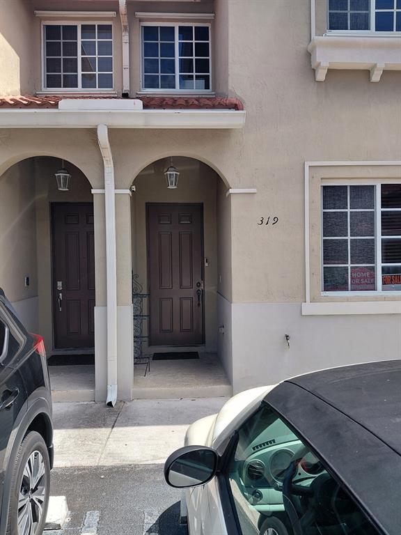 21205 Northwest 14th Place, Unit 319 Miami, FL 33169 - Photo 1 of 14 a view of a house with a large window and car parked