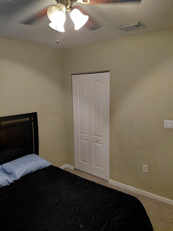 21205 Northwest 14th Place, Unit 319 Miami, FL 33169 - Photo 5 of 14 a bedroom with a bed and a chandelier