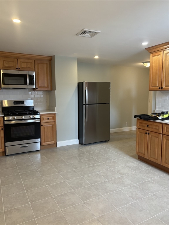 63 Callender Street, Unit 3R Boston, MA 02124 - Photo 2 of 24 a kitchen with stainless steel appliances a refrigerator and a stove top oven
