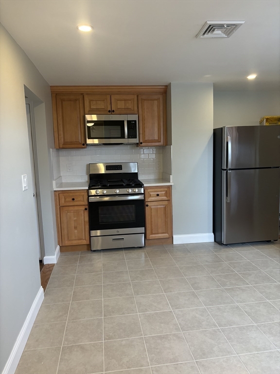 63 Callender Street, Unit 3R Boston, MA 02124 - Photo 5 of 24 a kitchen with stainless steel appliances a stove a microwave and a refrigerator