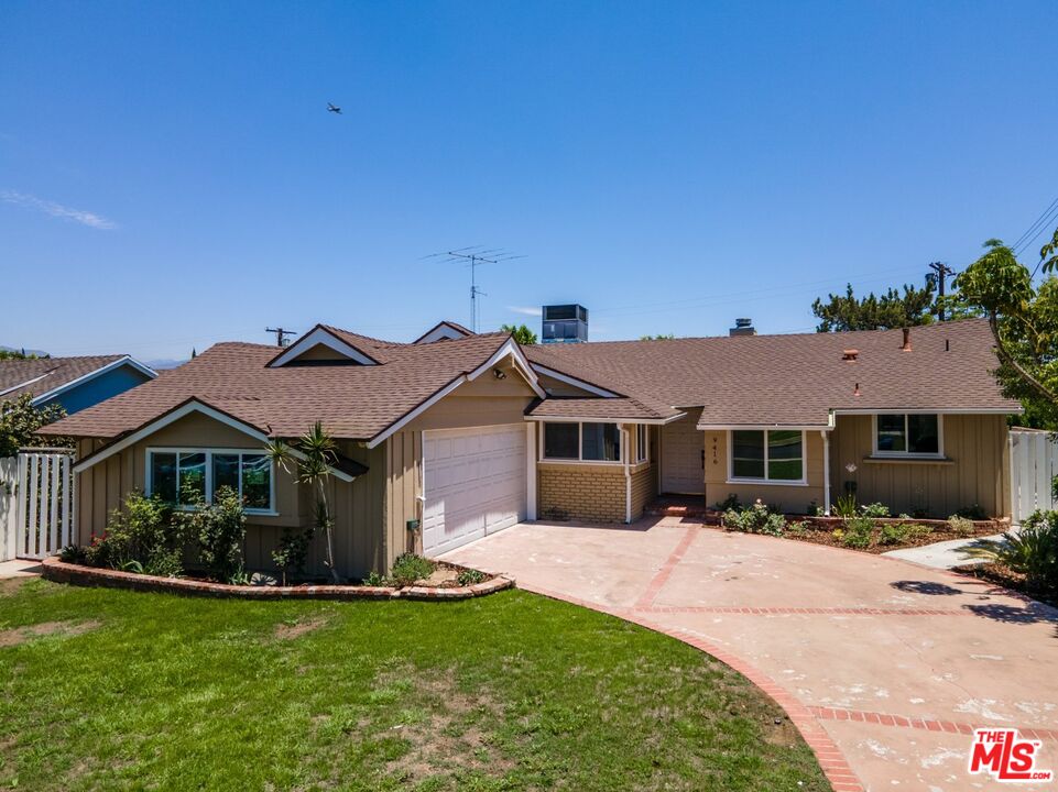 a front view of a house with a garden and yard