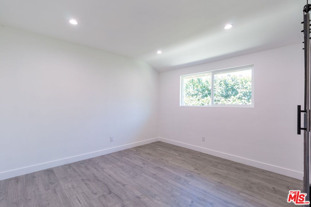 9416 Ruffner Avenue Northridge, CA 91343 - Photo 14 of 27 an empty room with wooden floor and windows