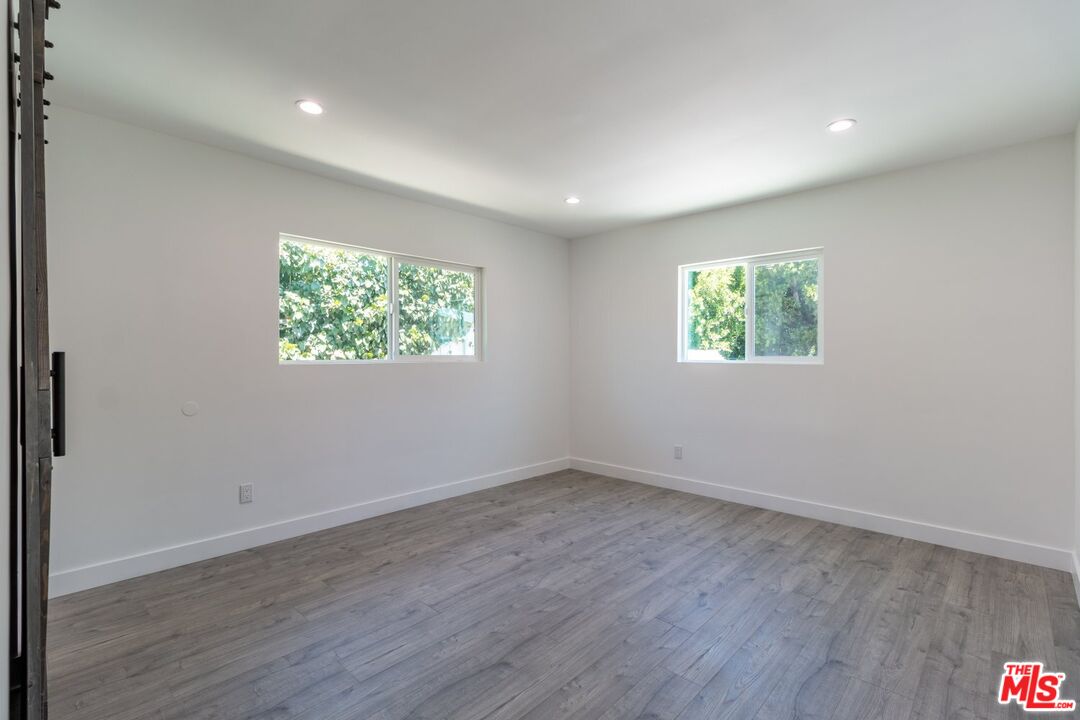 9416 Ruffner Avenue Northridge, CA 91343 - Photo 17 of 27 an empty room with wooden floor and windows