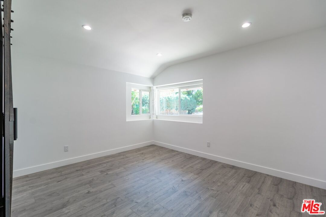 9416 Ruffner Avenue Northridge, CA 91343 - Photo 19 of 27 an empty room with wooden floor and windows