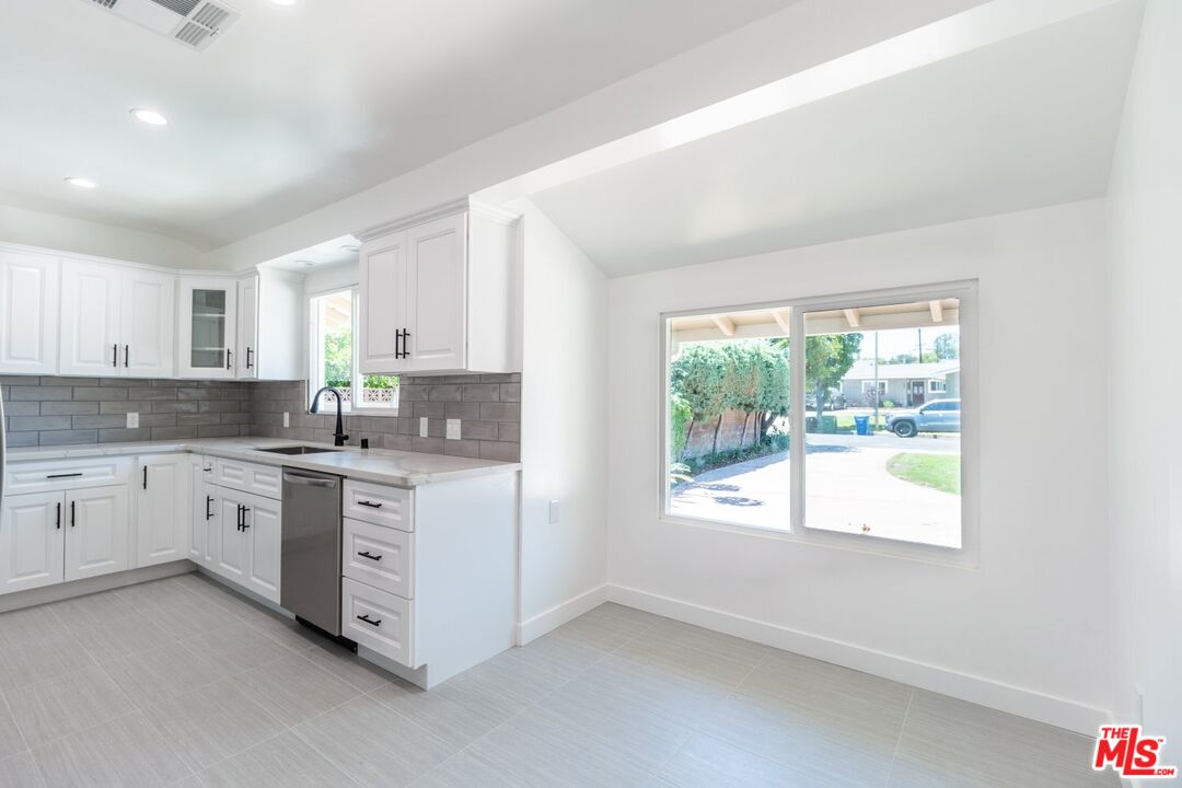 9416 Ruffner Avenue Northridge, CA 91343 - Photo 21 of 27 a kitchen with granite countertop white cabinets a window and a sink