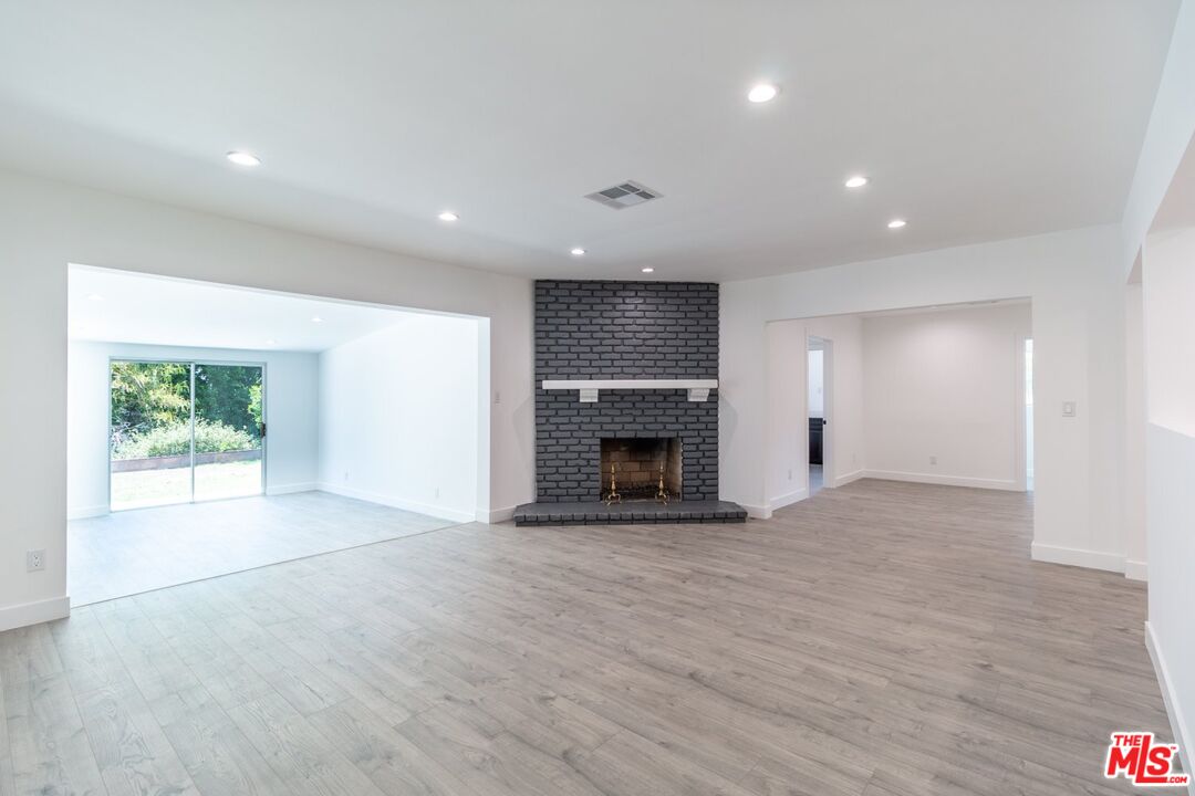9416 Ruffner Avenue Northridge, CA 91343 - Photo 3 of 27 a view of an empty room with a fireplace and a window