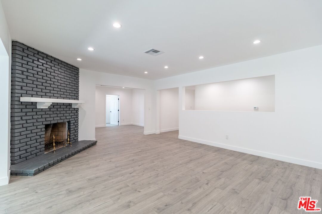 9416 Ruffner Avenue Northridge, CA 91343 - Photo 4 of 27 a view of empty room with wooden floor and fireplace