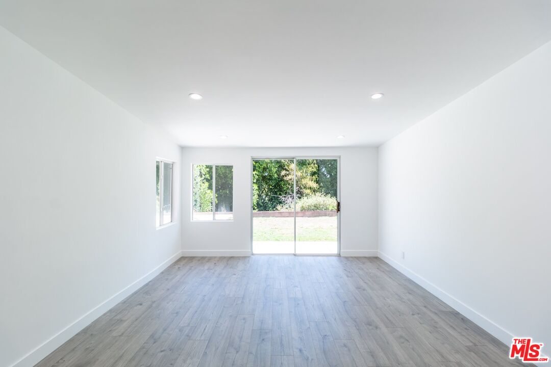 9416 Ruffner Avenue Northridge, CA 91343 - Photo 5 of 27 an empty room with wooden floor and windows