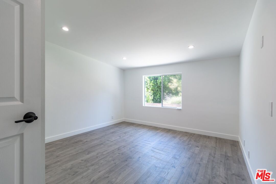 9416 Ruffner Avenue Northridge, CA 91343 - Photo 7 of 27 an empty room with wooden floor and a window