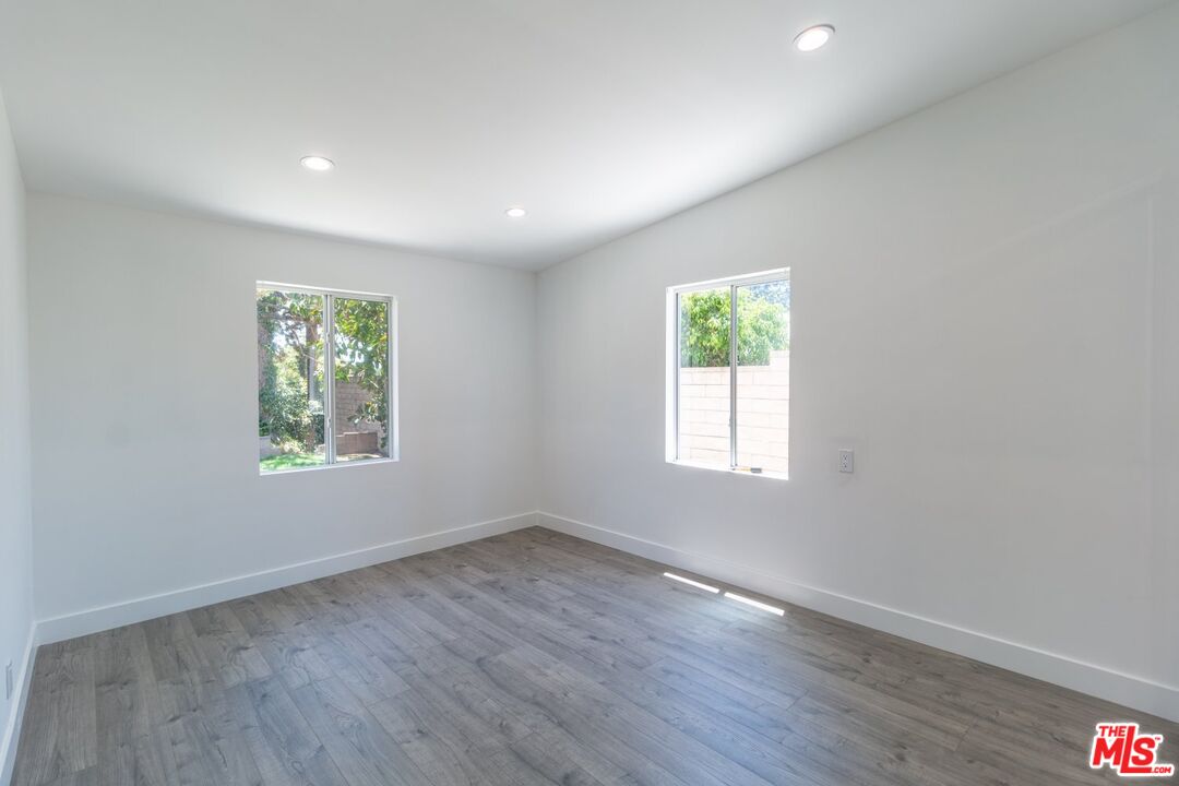 9416 Ruffner Avenue Northridge, CA 91343 - Photo 9 of 27 an empty room with wooden floor and window