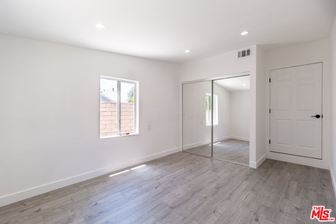 9416 Ruffner Avenue Northridge, CA 91343 - Photo 10 of 27 an empty room with wooden floor and window