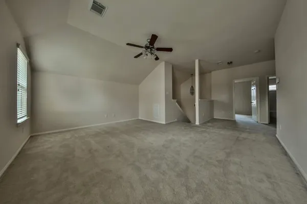 en empty room with windows and ceiling fan