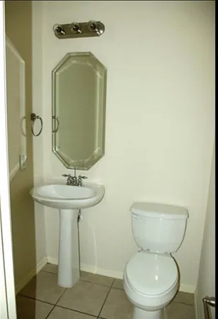 a bathroom with a toilet sink and mirror