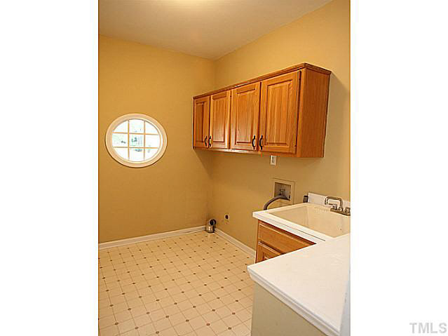 8405 Evans Mill Place Raleigh, NC 27613 - Photo 22 of 25 The main floor laundry has cabinets and the deirable utility sink. Laundry Room