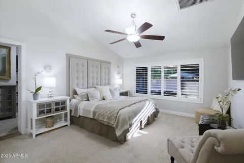 a spacious bedroom with a bed and ceiling fan