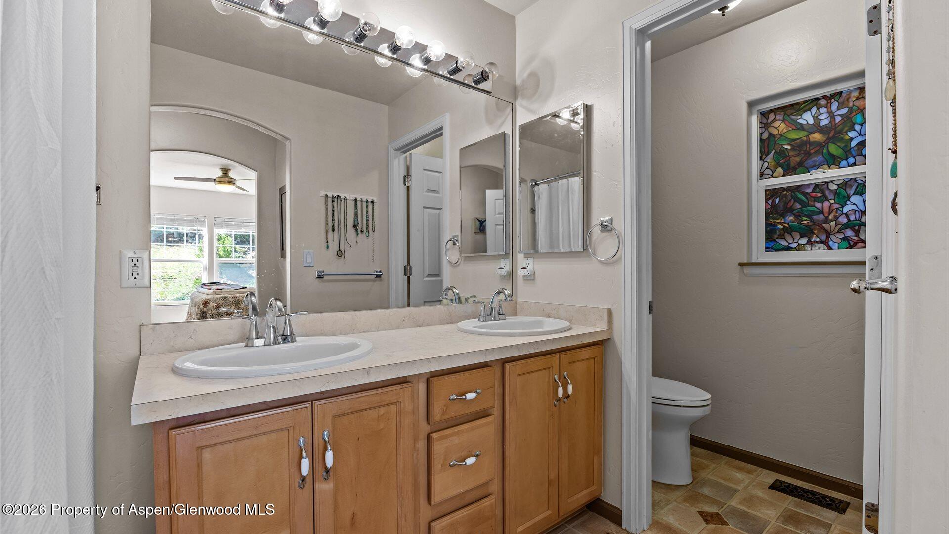 606 Lariat Loop New Castle, CO 81647 - Photo 14 of 27 a bathroom with a granite countertop sink a toilet and a mirror
