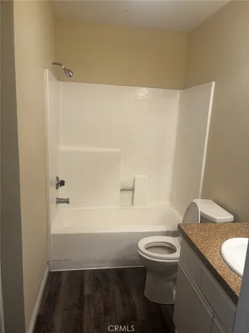 a bathroom with a granite countertop toilet a sink and bathtub