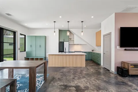 a kitchen with stainless steel appliances kitchen island granite countertop a table and chairs in it