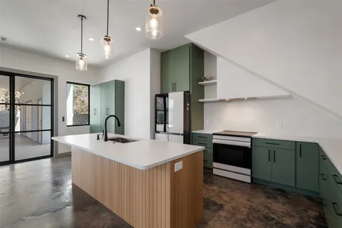 a kitchen with stainless steel appliances granite countertop a sink a stove and a refrigerator