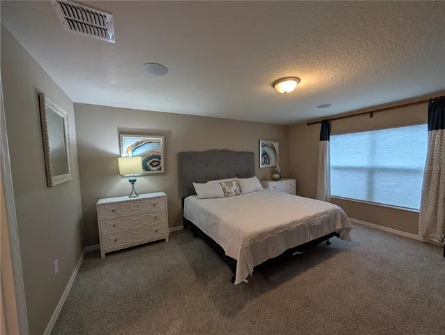 a spacious bedroom with a bed and a window