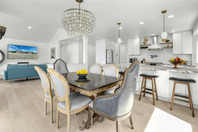 a view of a dining room and livingroom with furniture wooden floor a chandelier