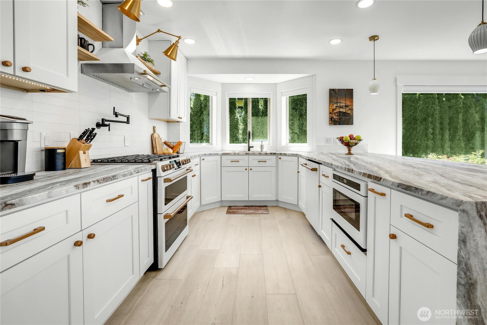 14938 Channel Lane La Conner, WA 98257 - Photo 14 of 40 a large white kitchen with stainless steel appliances granite countertop a stove a sink dishwasher and white cabinets with wooden floor