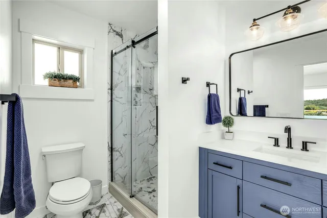 a bathroom with a sink a mirror a toilet and shower