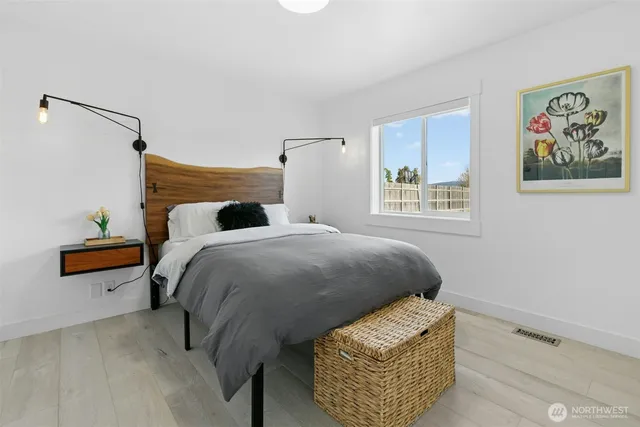 a bedroom with a bed and a painting on the wall