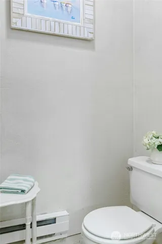 a white toilet sitting next to a white wall