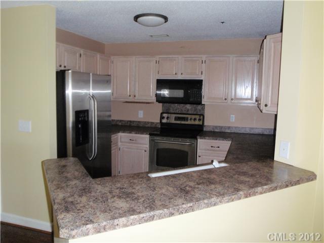 1133 Torrence Circle, Unit 1133 Davidson, NC 28036 - Photo 2 of 11 a kitchen with a refrigerator and a sink