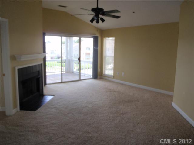 1133 Torrence Circle, Unit 1133 Davidson, NC 28036 - Photo 3 of 11 a view of an empty room with a fireplace and a window
