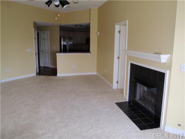 1133 Torrence Circle, Unit 1133 Davidson, NC 28036 - Photo 4 of 11 a view of an empty room with a fireplace and cabinet