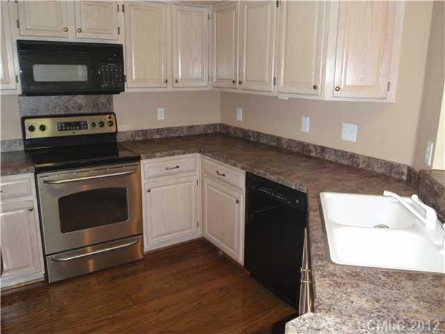 1133 Torrence Circle, Unit 1133 Davidson, NC 28036 - Photo 7 of 11 a kitchen with granite countertop white cabinets and stainless steel appliances