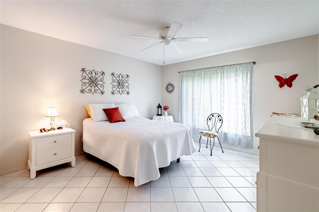 2296 Monaco Lane, Unit 8 Clearwater, FL 33763 - Photo 12 of 28 a bedroom with a bed and a chandelier