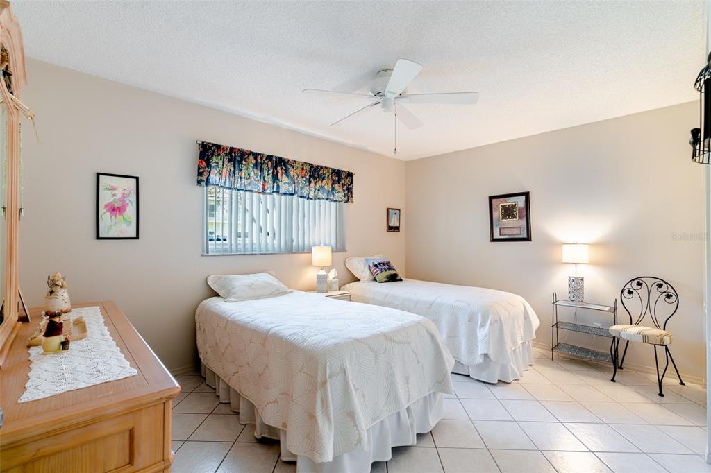 2296 Monaco Lane, Unit 8 Clearwater, FL 33763 - Photo 17 of 28 a bedroom with a bed and a chandelier