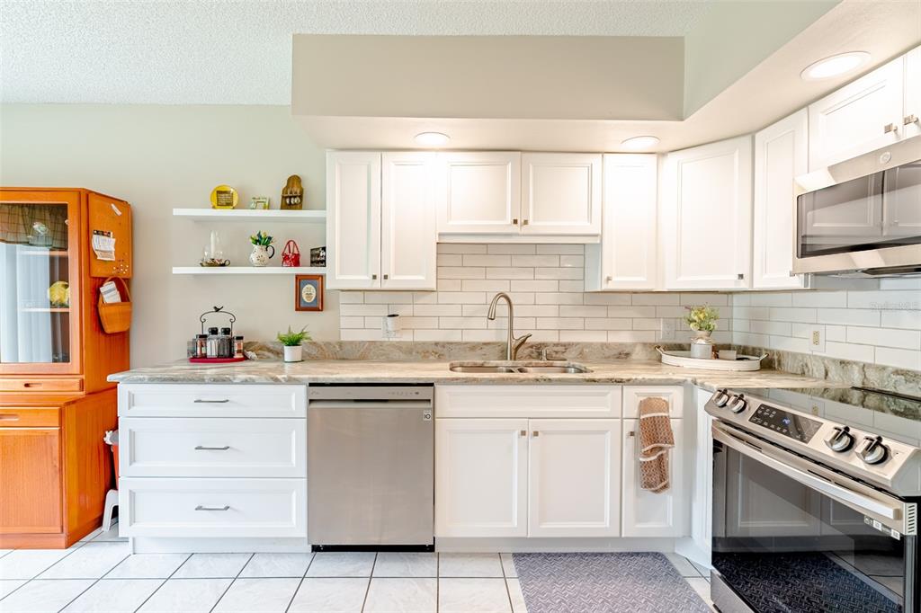 2296 Monaco Lane, Unit 8 Clearwater, FL 33763 - Photo 5 of 28 a kitchen with white cabinets stainless steel appliances and sink