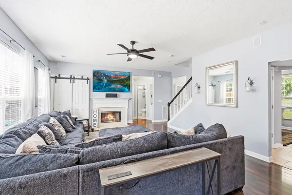 a bedroom with a bed a flat screen tv and a wall painting