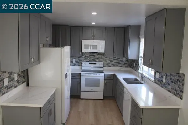 a kitchen with sink a stove and cabinets