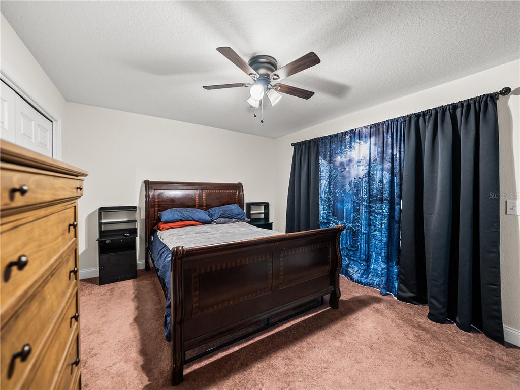 609 West Pipkin Road Lakeland, FL 33813 - Photo 37 of 72 a bed room with a bed and a ceiling fan