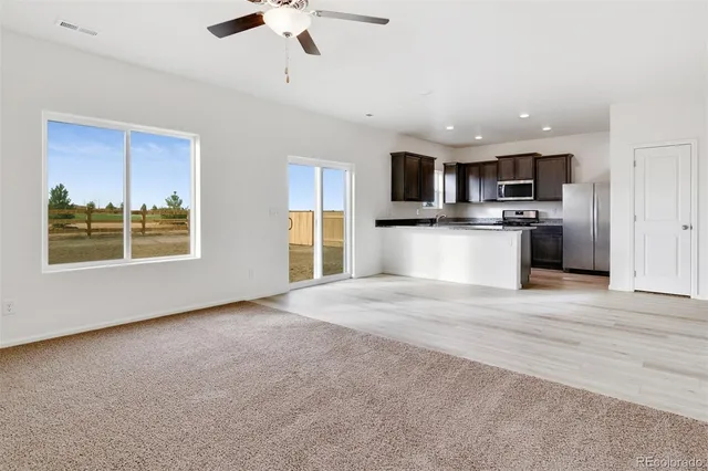 a view of kitchen with kitchen island stainless steel appliances refrigerator stove microwave and cabinets