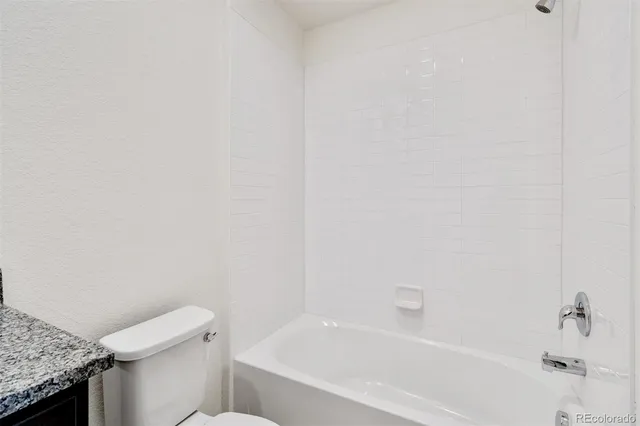 a white bath tub sitting next to a white toilet