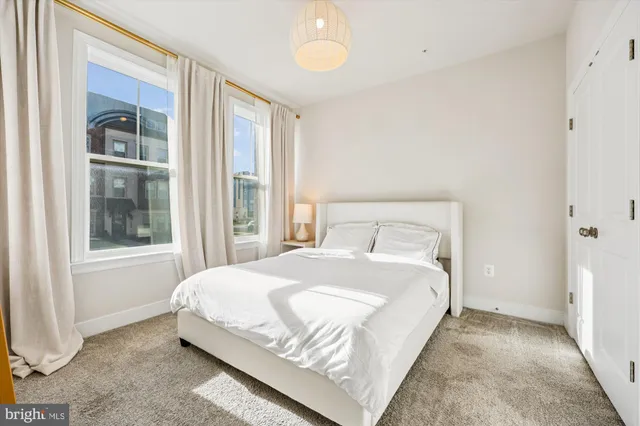 a large bed sitting in a bedroom next to a window