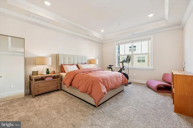 a spacious bedroom with a bed and wooden floor