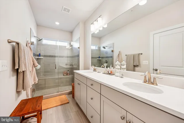 a bathroom with a sink double vanity mirror and a bathtub