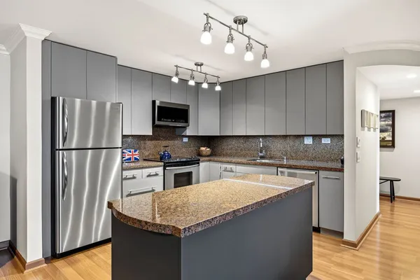 a kitchen with granite countertop a refrigerator and a sink