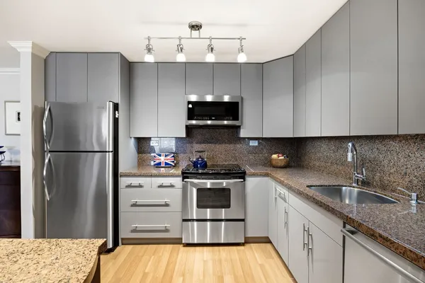 a kitchen with a sink a refrigerator and cabinets
